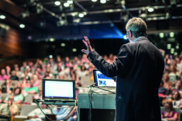 Public speaker giving talk at Business Event.